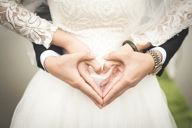 De oorsprong van Valentijnsdag en hoe vieren andere landen deze dag? - bruidspaar met handen in hartvorm
